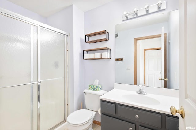 bathroom with vanity, toilet, and a shower with door