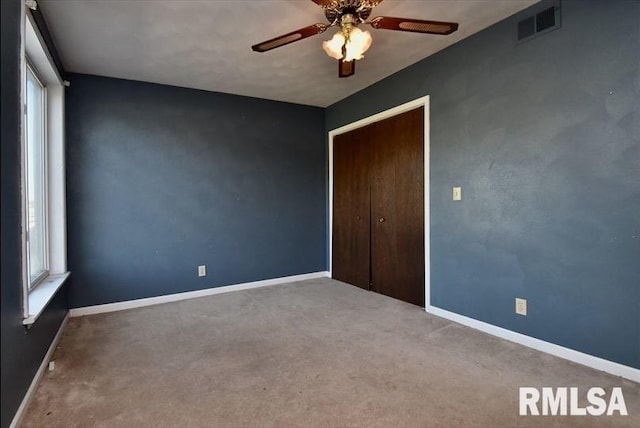 spare room featuring carpet floors, a healthy amount of sunlight, and ceiling fan