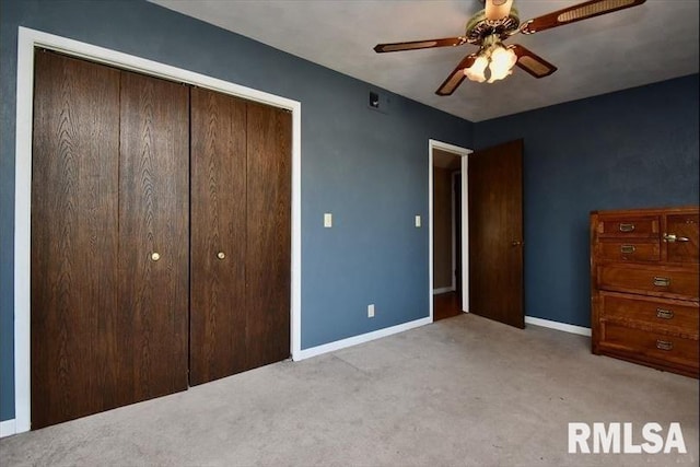 unfurnished bedroom featuring ceiling fan, a closet, and light carpet