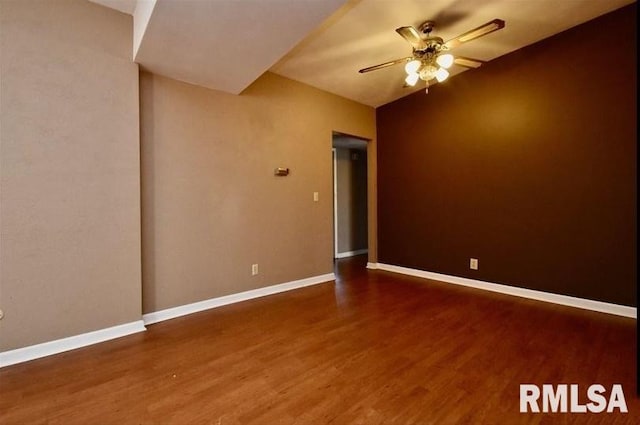 empty room with ceiling fan and dark wood-type flooring