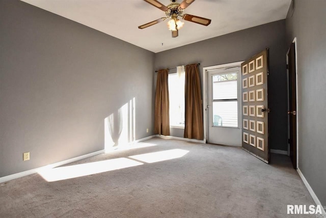 carpeted spare room featuring ceiling fan