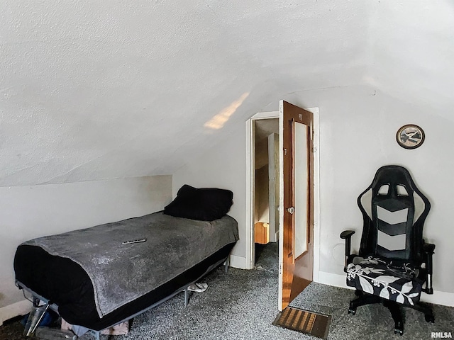 carpeted bedroom with lofted ceiling and a textured ceiling