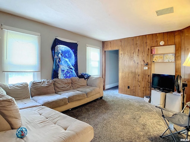 living room with dark carpet and wooden walls