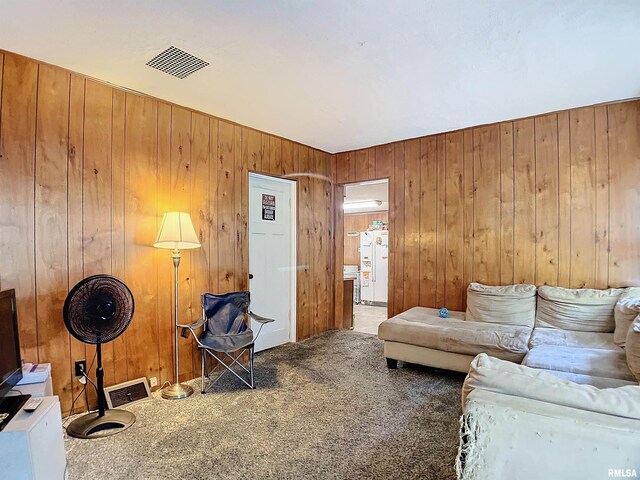 carpeted living room with wooden walls