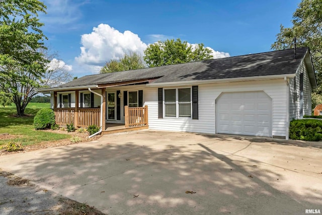 ranch-style home featuring covered porch and a garage