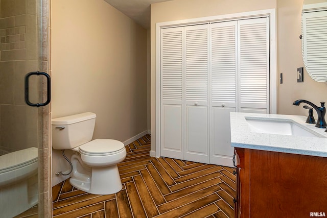 bathroom featuring parquet flooring, vanity, toilet, and walk in shower