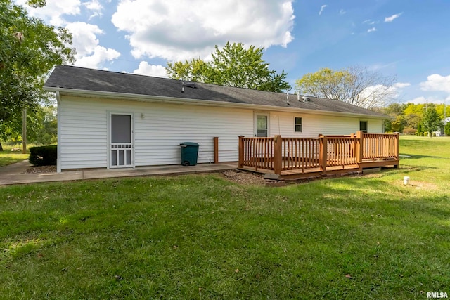 rear view of house with a wooden deck and a yard