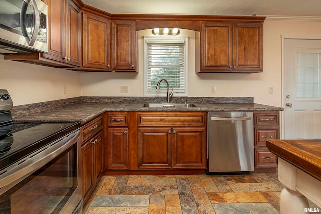 kitchen featuring stainless steel appliances, sink, and dark stone counters