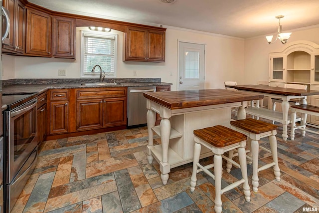 kitchen featuring a breakfast bar area, sink, crown molding, a notable chandelier, and appliances with stainless steel finishes