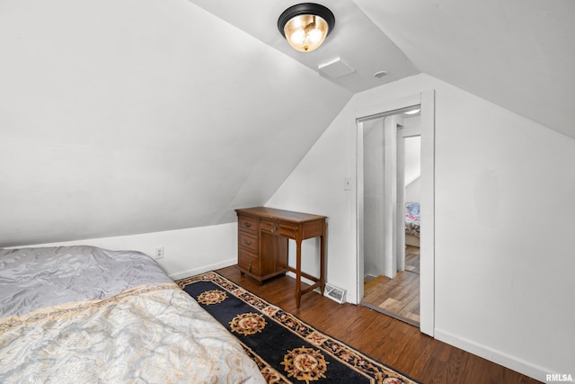 bedroom with vaulted ceiling and hardwood / wood-style flooring