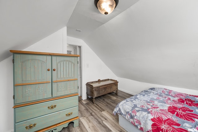 bedroom with vaulted ceiling and light hardwood / wood-style floors