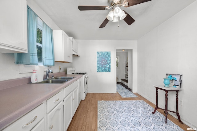 kitchen with white range, light wood-type flooring, white cabinetry, and ceiling fan