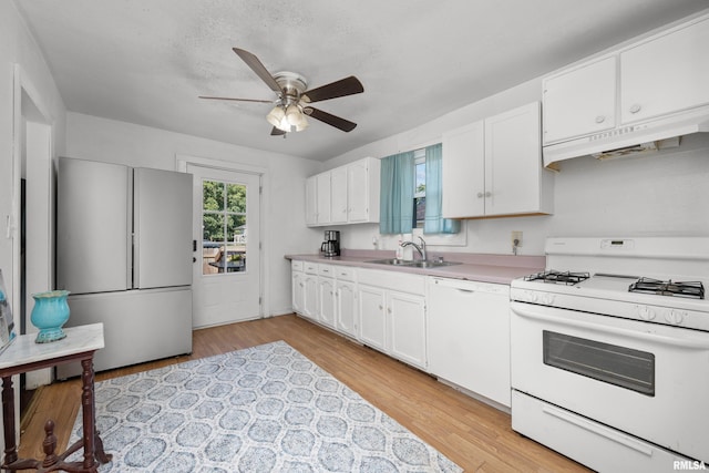 kitchen featuring ceiling fan, white cabinets, light wood-type flooring, and white appliances