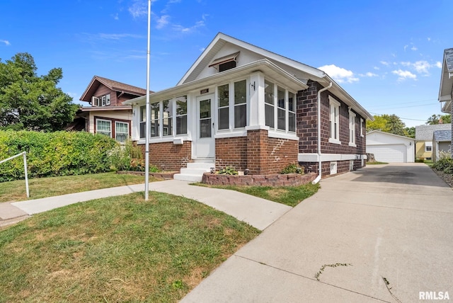 view of front of house with a front lawn, an outbuilding, and a garage