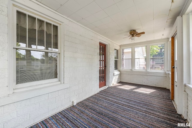 unfurnished sunroom featuring ceiling fan