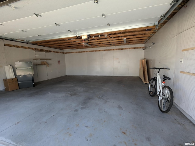 garage with a garage door opener and fridge