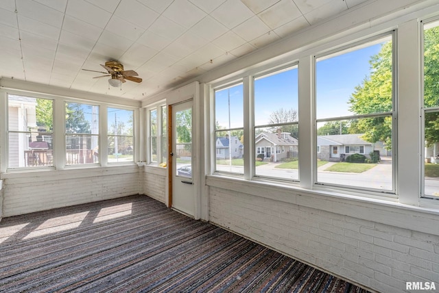 unfurnished sunroom with ceiling fan