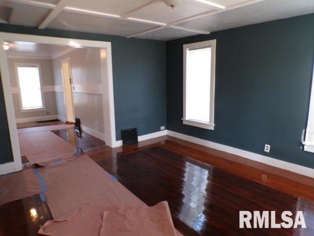 unfurnished living room featuring wood-type flooring and coffered ceiling