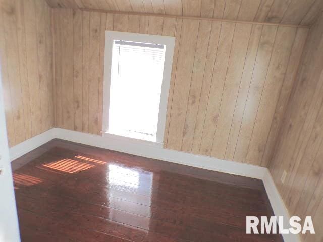 unfurnished room featuring wooden ceiling, wood walls, and dark hardwood / wood-style floors