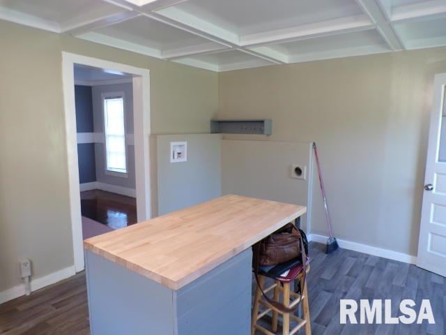 kitchen featuring coffered ceiling, beamed ceiling, a kitchen breakfast bar, and dark hardwood / wood-style flooring