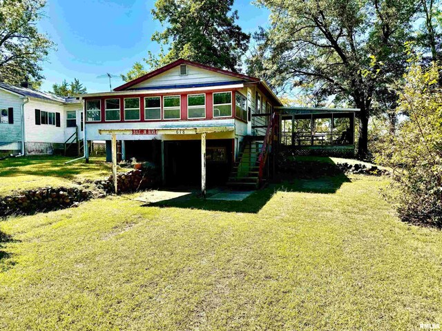 rear view of property featuring a sunroom and a yard