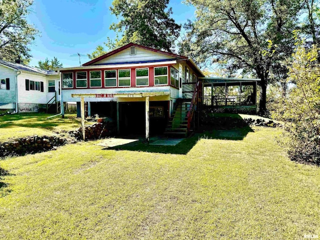 rear view of property featuring a sunroom and a yard