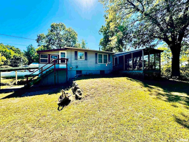 back of house featuring a sunroom and a yard