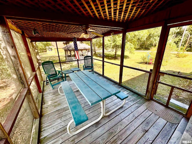 unfurnished sunroom with ceiling fan