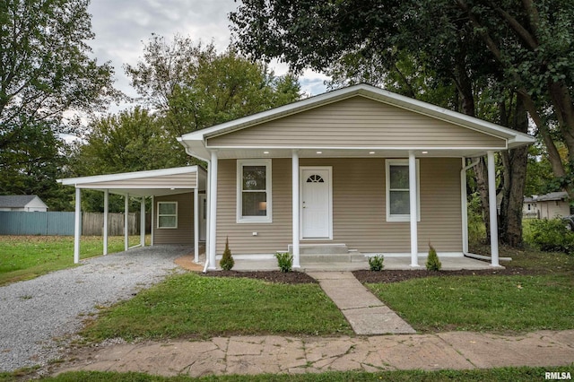 bungalow-style house featuring a front yard, a porch, and a carport