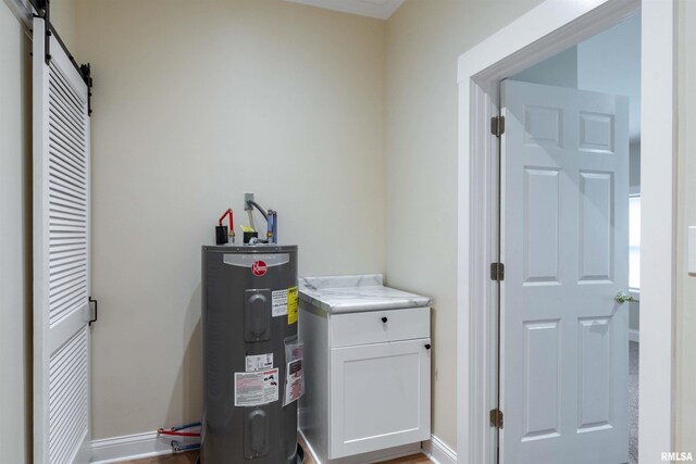 washroom featuring a barn door, electric water heater, and hardwood / wood-style flooring