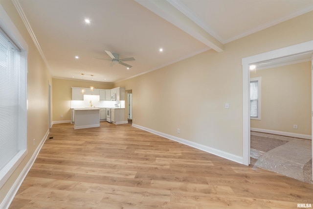 unfurnished bedroom featuring beamed ceiling, light hardwood / wood-style flooring, crown molding, and sink