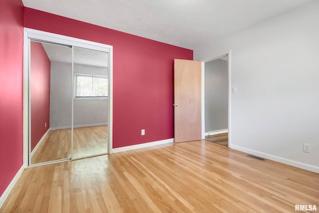 unfurnished bedroom with wood-type flooring and a closet