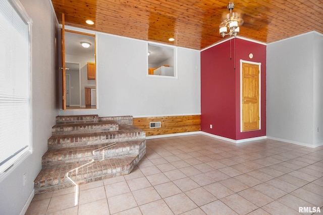 spare room with wood walls, wooden ceiling, and light tile patterned floors