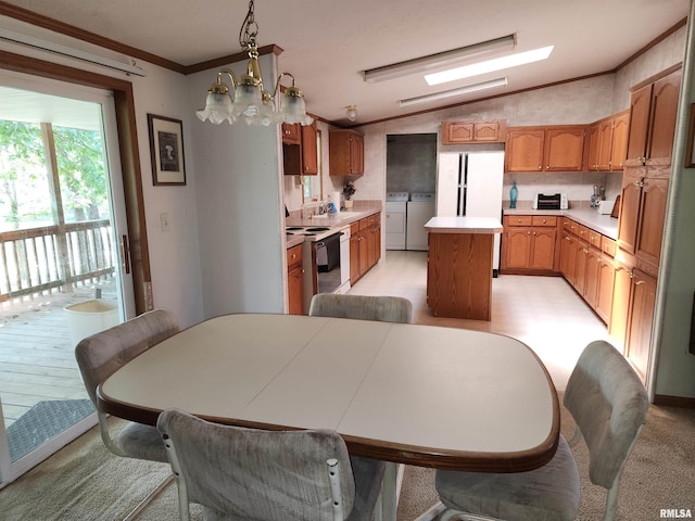 dining area with vaulted ceiling, separate washer and dryer, ornamental molding, sink, and a notable chandelier