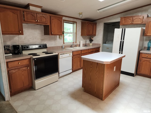 kitchen featuring ornamental molding, sink, white appliances, a kitchen island, and washer / dryer