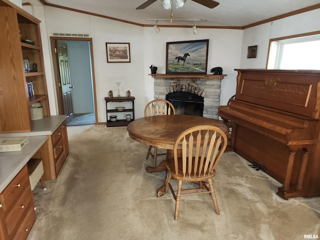 interior space with ornamental molding, lofted ceiling, ceiling fan, and a stone fireplace