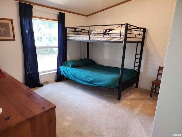 bedroom with light carpet, lofted ceiling, and ornamental molding