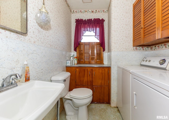 bathroom with separate washer and dryer, sink, and toilet