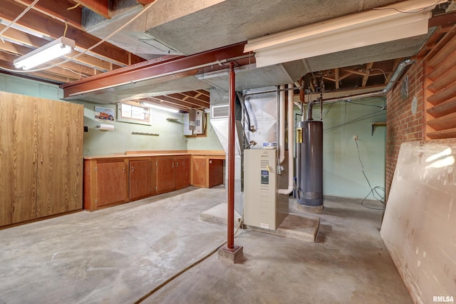 basement featuring a workshop area, heating unit, and water heater