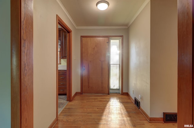 foyer with light wood-type flooring and ornamental molding