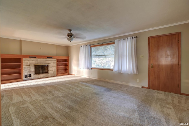 unfurnished living room featuring carpet, a stone fireplace, ceiling fan, and ornamental molding