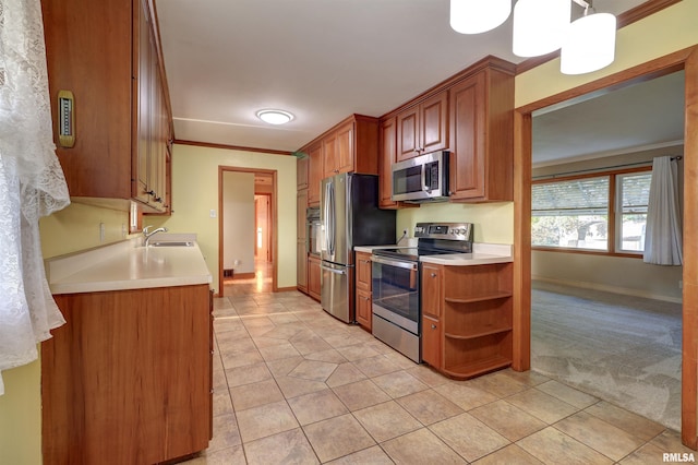 kitchen featuring light colored carpet, ornamental molding, decorative light fixtures, and appliances with stainless steel finishes