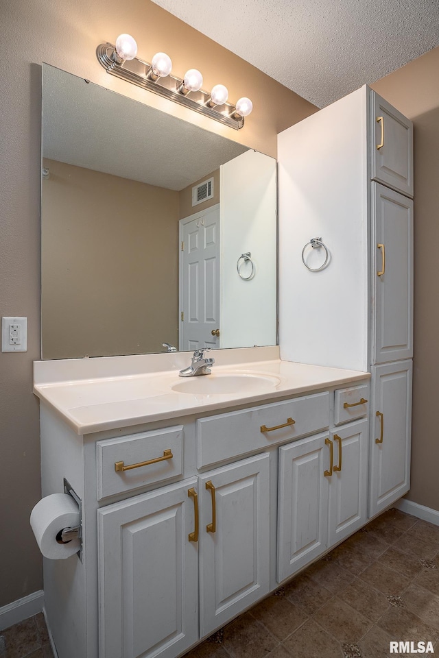 bathroom with a textured ceiling and vanity