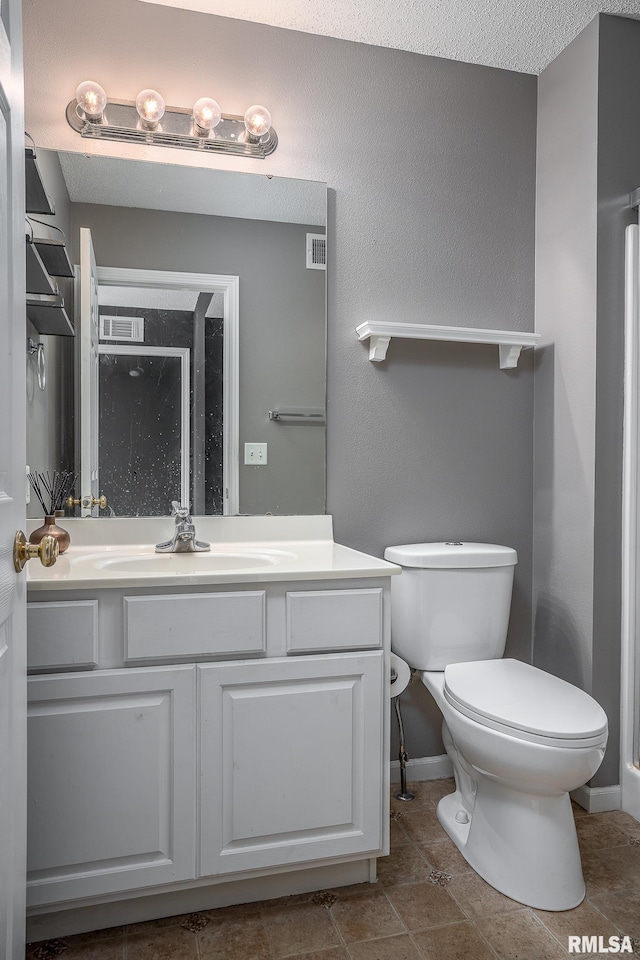 bathroom featuring vanity, tile patterned flooring, toilet, and a textured ceiling