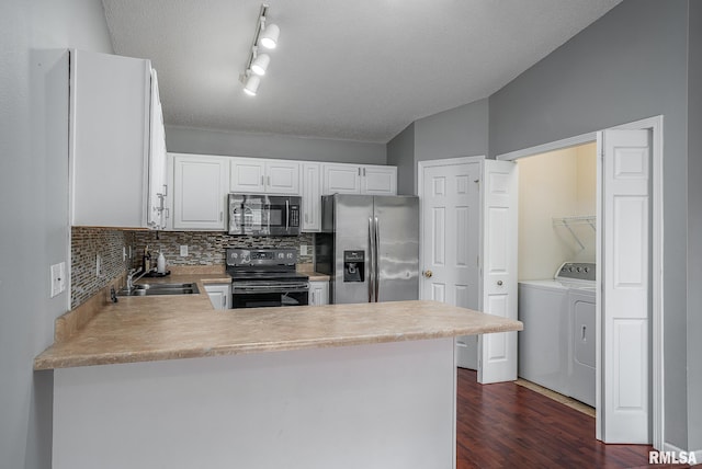 kitchen with white cabinetry, kitchen peninsula, appliances with stainless steel finishes, and separate washer and dryer