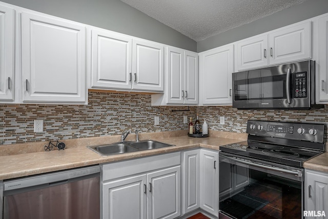 kitchen featuring tasteful backsplash, sink, lofted ceiling, white cabinetry, and stainless steel appliances