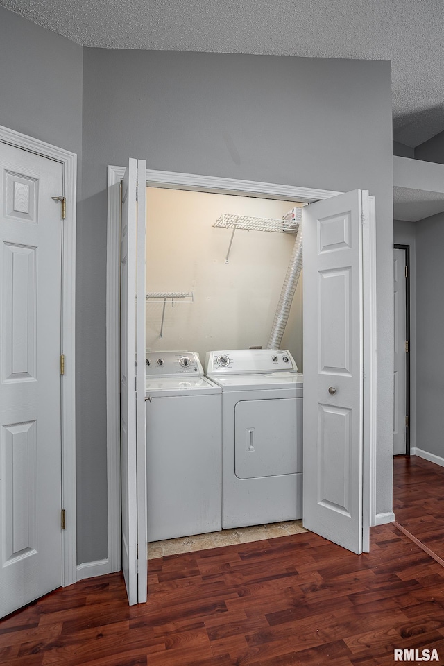 laundry room with washer and clothes dryer, a textured ceiling, and dark hardwood / wood-style floors