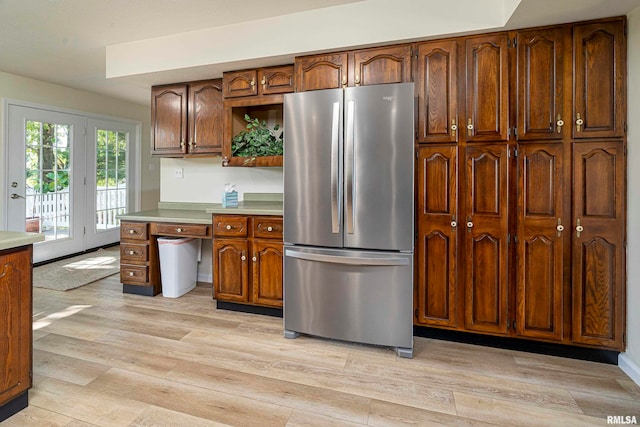 kitchen with stainless steel refrigerator and light hardwood / wood-style flooring