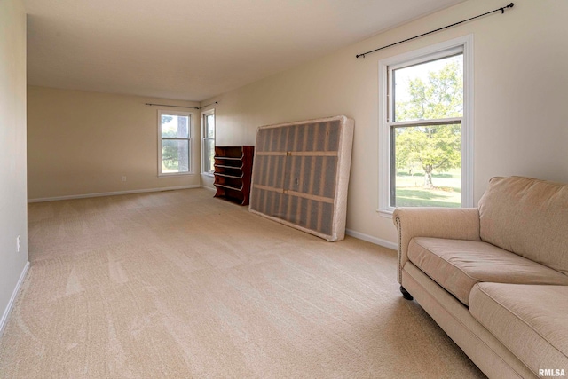 living area with light carpet and a healthy amount of sunlight