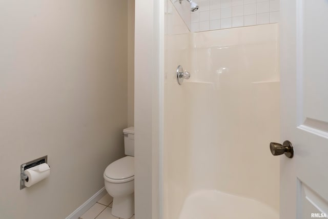 bathroom featuring a tile shower, toilet, and tile patterned floors